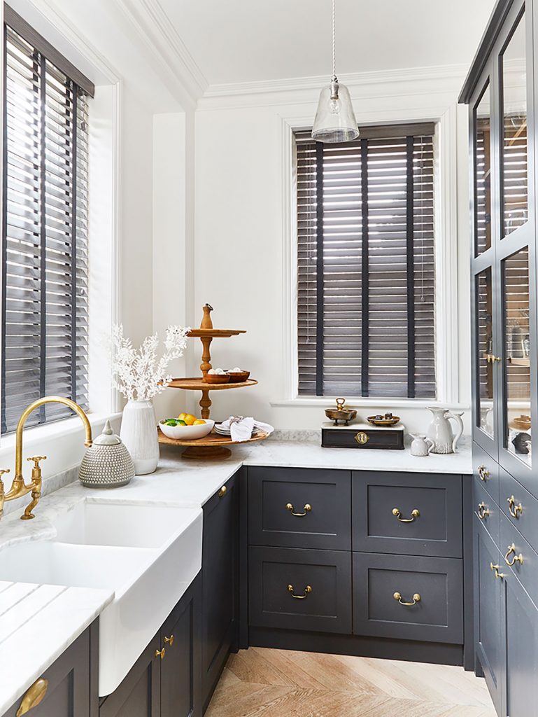 A kitchen space with blinds fitted to the windows with contrasting colours to create an impactful and light interior.