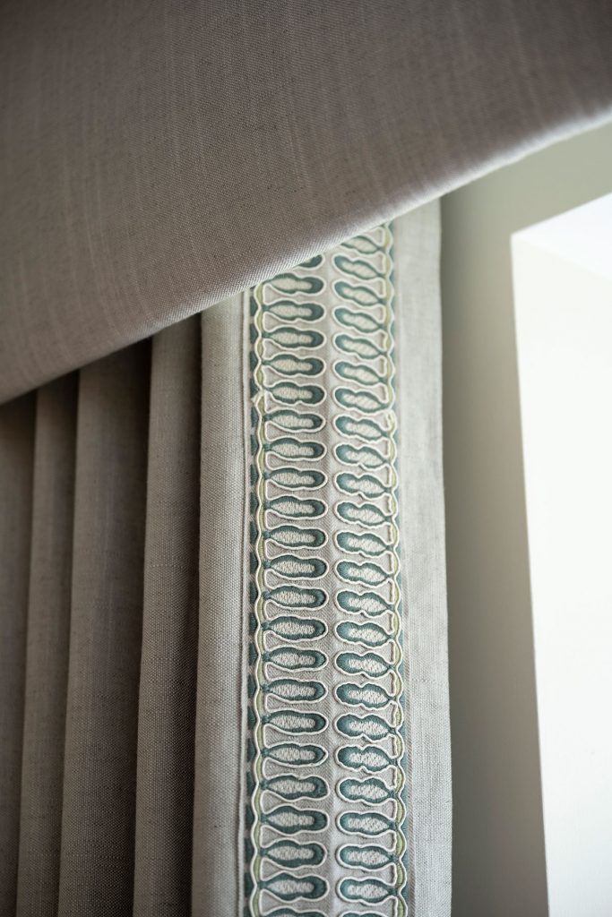 Valence fitted to the top of curtains, hiding the track. Detailed edging with small design.